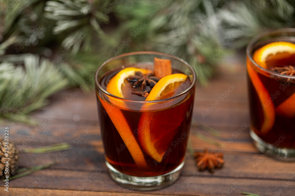 Christmas mulled red wine with spices on a wooden rustic table. Traditional hot drink at Christmas time Christmas mulled red wine with spices on a wooden rustic table. Traditional hot drink at Christmas time