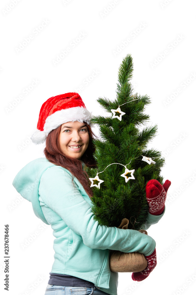 Photo of woman in Santa's cap with Christmas tree in hand