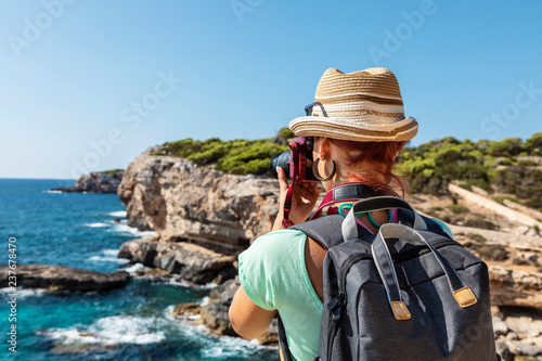 Young woman taking pictures of a beautiful scene