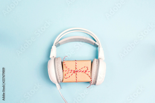 White headphones with gift box on a blue background.
