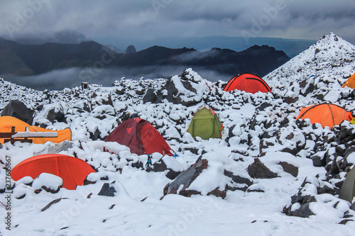 colorful tents in the snow. Climbers wait out bad weather in tents. Base camp on the northern slope of Elbrus. photo