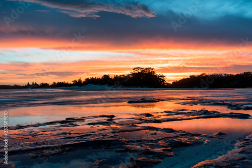 Orange Australian Sunset Ocean Reflection over Rocks