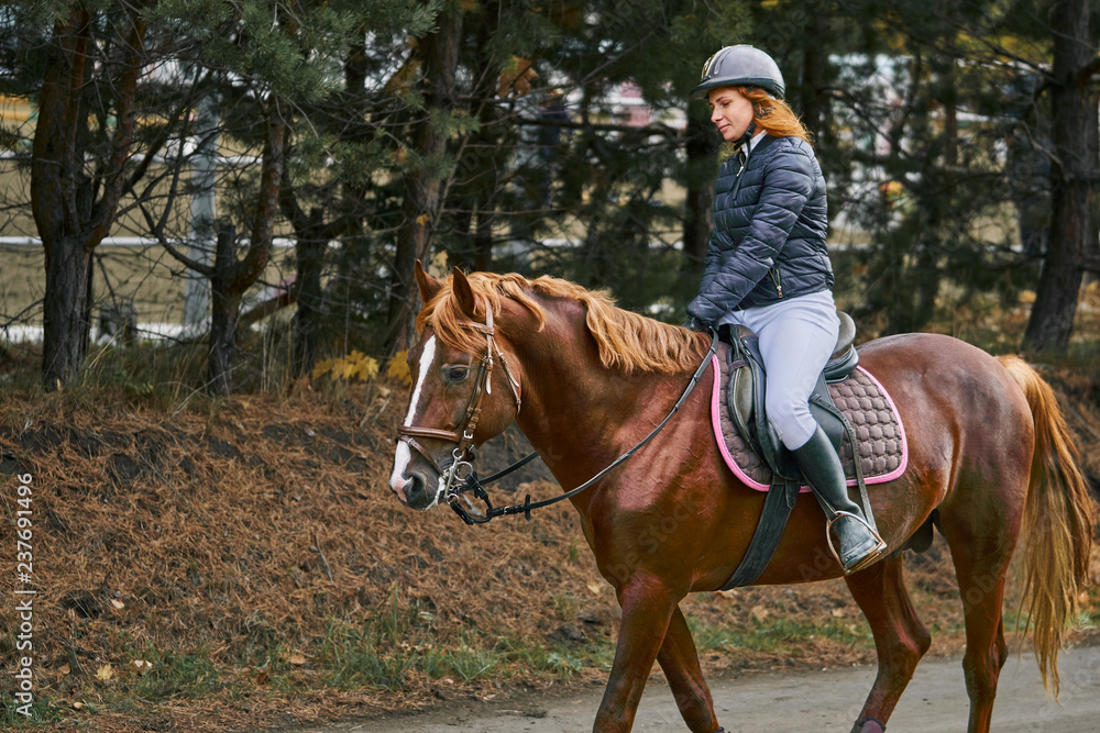 Young woman jockey in white black dress and black boots, takes part in equestrian competitions. Young woman jockey in white black dress and black boots, takes part in equestrian competitions.