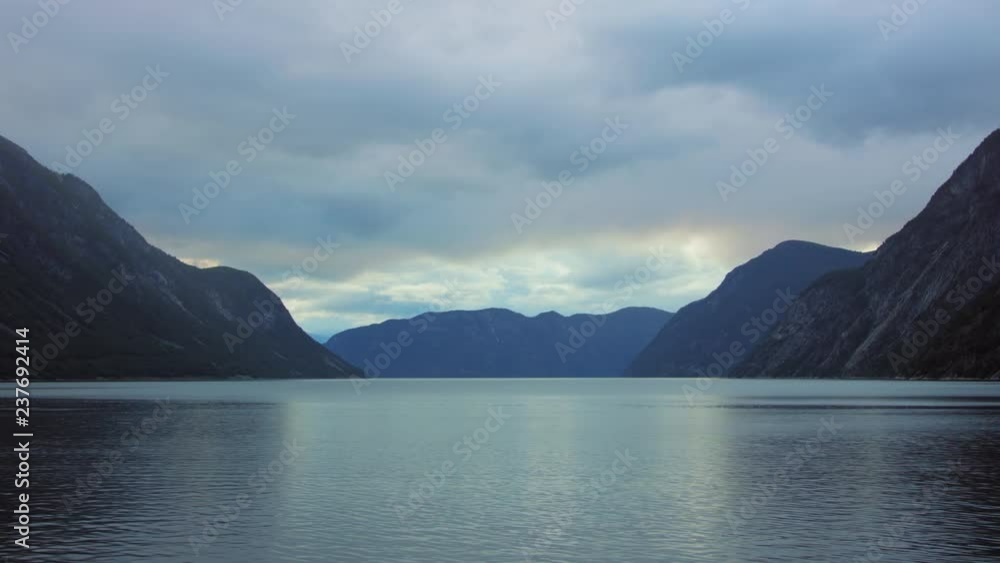 Reflecting sea water surface slow motion in Norwegian fjord between high mountains Reflecting sea water surface slow motion in Norwegian fjord between high mountains