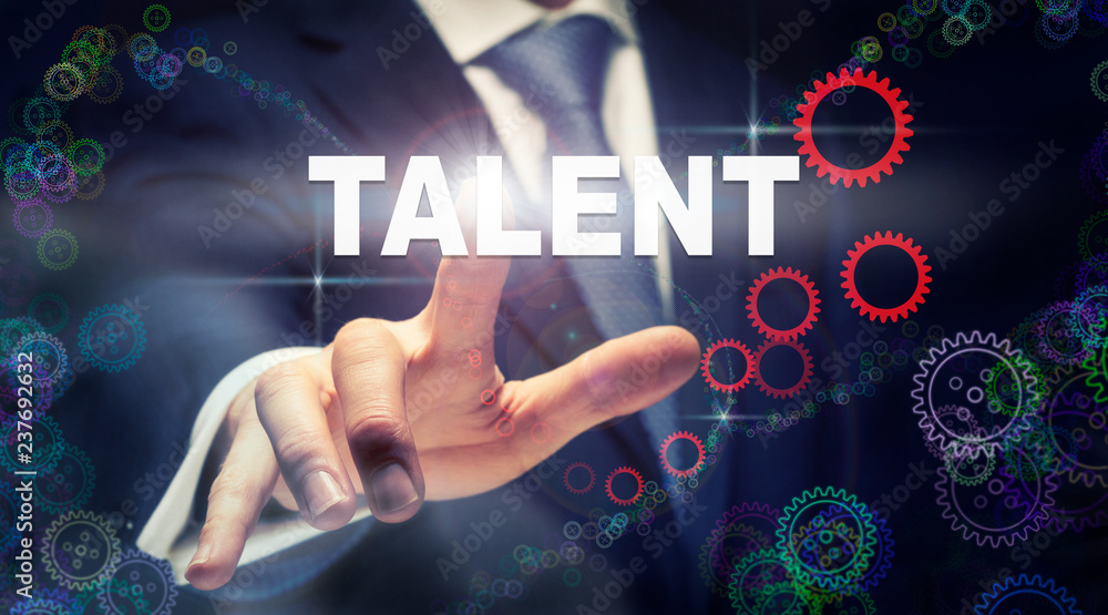 A businessman pressing a Talent business concept on a graphical display of cogs A businessman pressing a Talent business concept on a graphical display of cogs