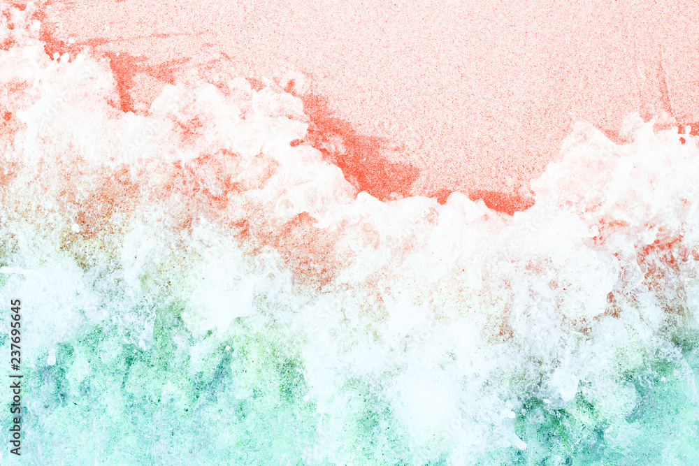 Soft waves with foam on sandy beach toned in trendy colors of the year 2019. Living Coral and Limpet Shell. - obrazy, fototapety, plakaty 