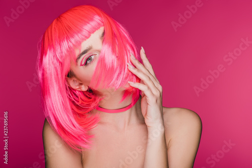 beautiful stylish model posing in neon pink wig, isolated on pink