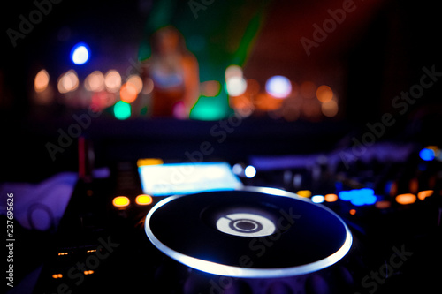 club DJ in headphones with sound mixer in nightclub