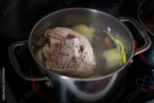 Boiled chicken with onion in stainless pot. Shallow depth of field.
