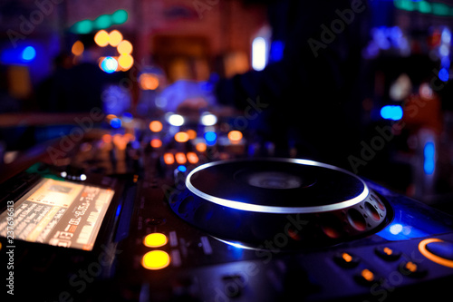 DJ behind the decks in a nightclub. DJ spinning plate. people dancing in a nightclub. disco