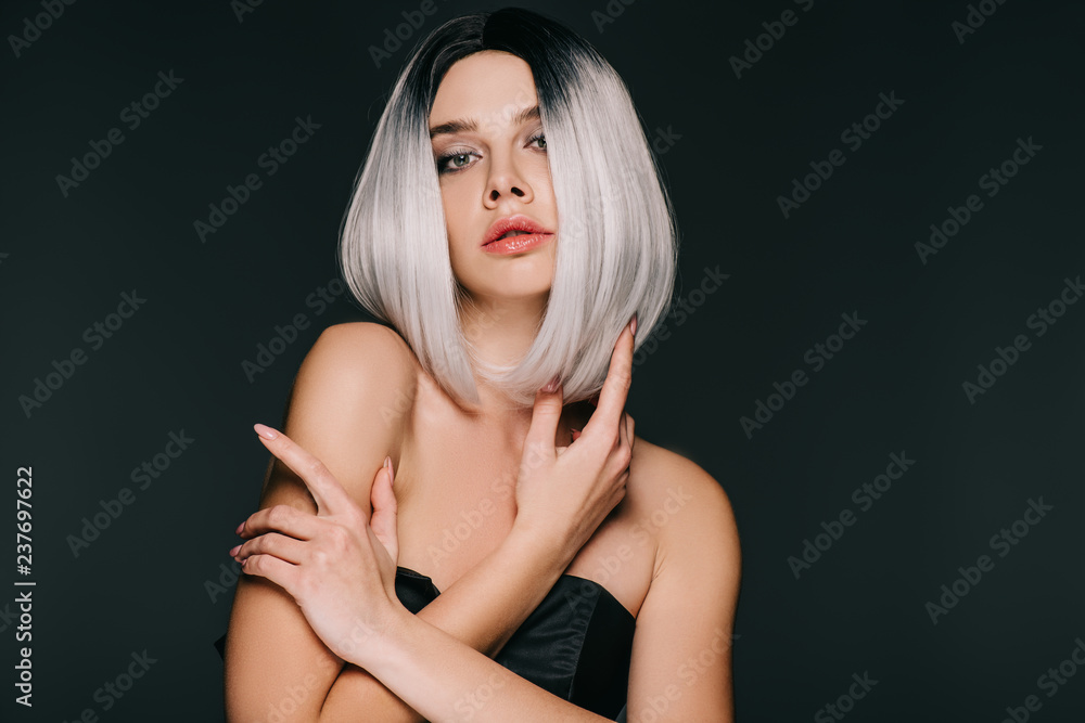beautiful fashionable young woman posing in grey wig, isolated on black