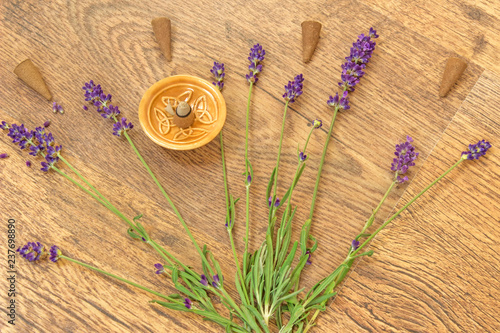 Fototapeta Naklejka Na Ścianę i Meble -  Cones incense and lavender flowers on a wooden table - aromatherapy theme background.