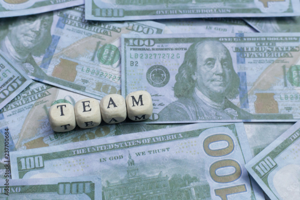 Fototapeta premium Team word on wood brick background banknote..