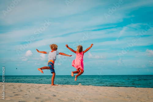 happy little boy and girl enjoy play jump on beach