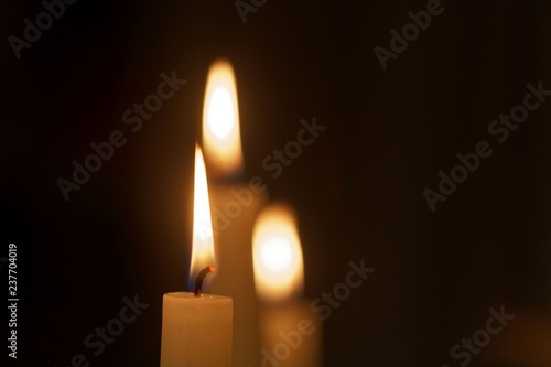Three candle flames with a dark background