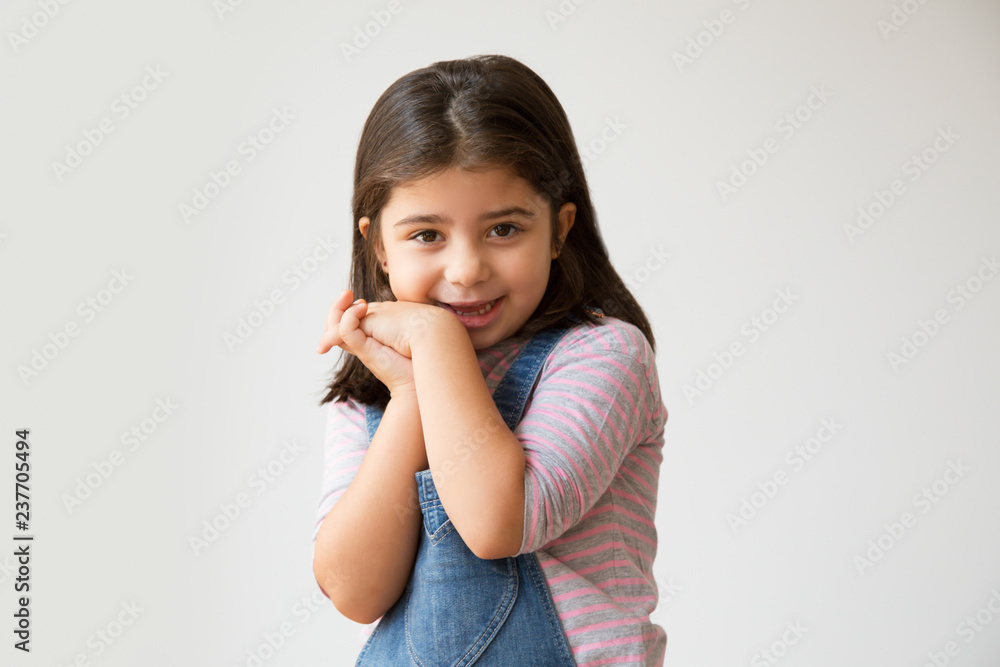 Cute Hispanic child in denim overalls smiling at camera. Cheerful little kid in casual clothing. Isolated on white. Happiness concept Cute Hispanic child in denim overalls smiling at camera. Cheerful little kid in casual clothing. Isolated on white. Happiness concept