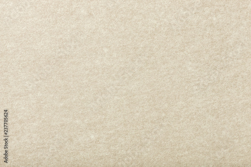 Light beige matt suede fabric closeup. Velvet texture of felt.