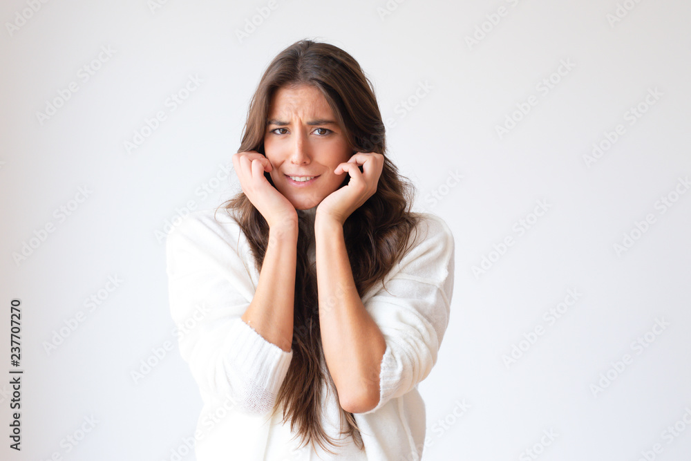 Frightened Hispanic girl with hands nead face looking at camera. Beautiful stressed young woman. Isolated on white with copy space. Stress concept Frightened Hispanic girl with hands nead face looking at camera. Beautiful stressed young woman. Isolated on white with copy space. Stress concept