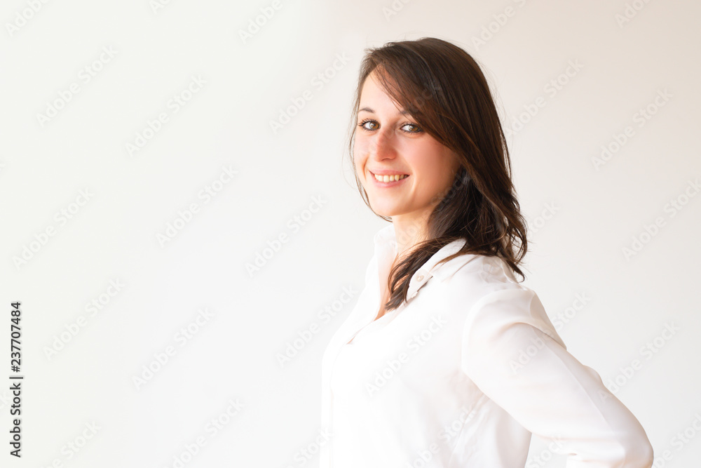 Happy student in white blouse looking at camera. Side view of smiling young office worker. Isolated on white. Beauty concept Happy student in white blouse looking at camera. Side view of smiling young office worker. Isolated on white. Beauty concept