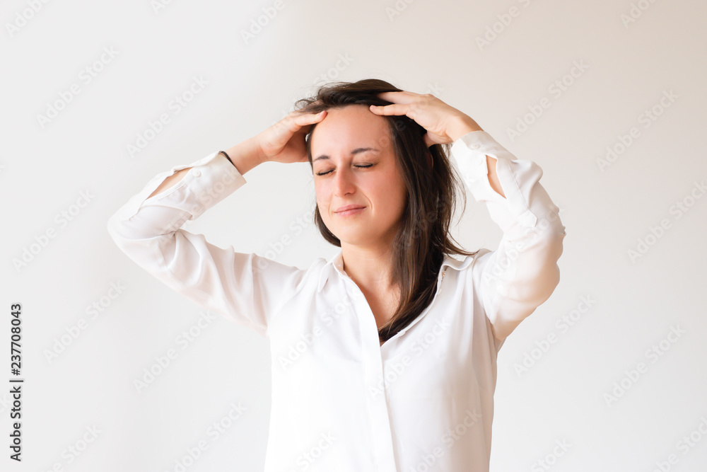 Tired female student touching painful temples. Portrait of young manager with closed eyes having headache. Isolated on white. Headache concept Tired female student touching painful temples. Portrait of young manager with closed eyes having headache. Isolated on white. Headache concept