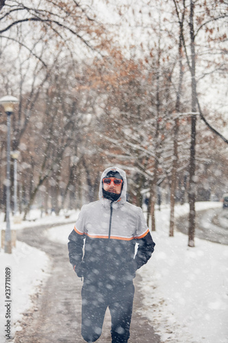 Man jogging in a cold winter snowy day outdoors. © astrosystem