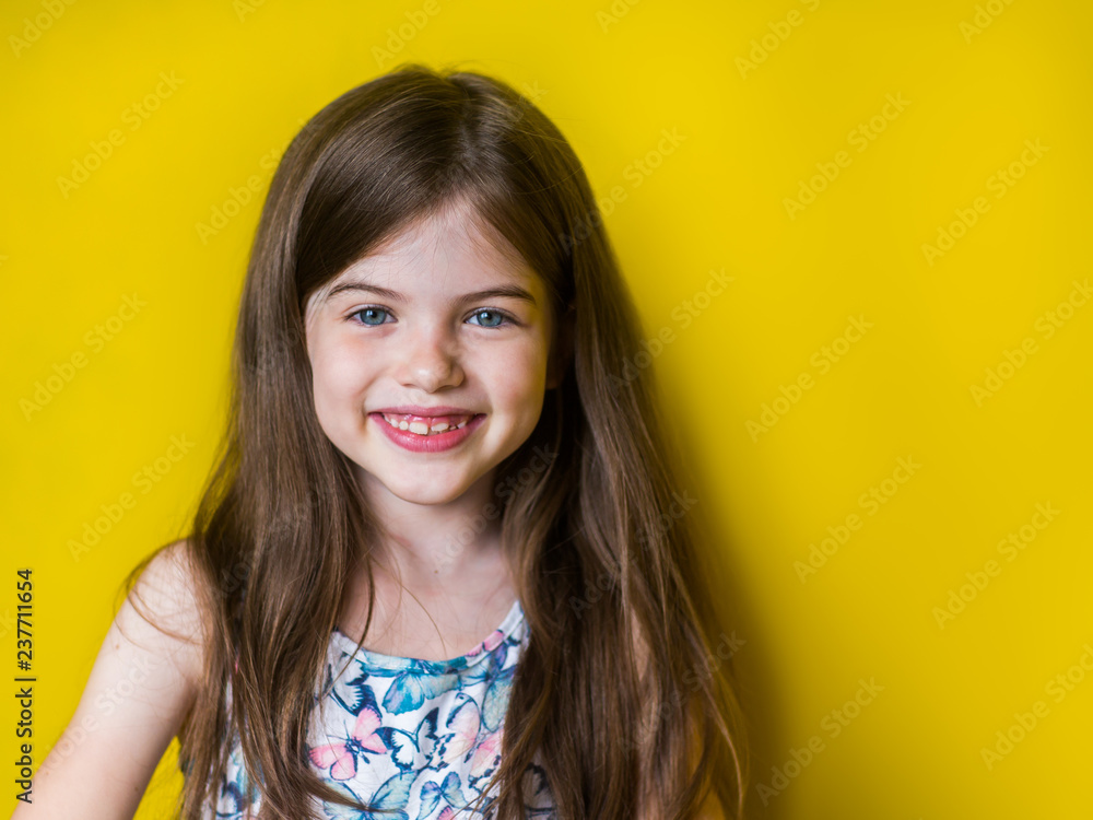 portrait of cute little smiling girl on yellow background portrait of cute little smiling girl on yellow background