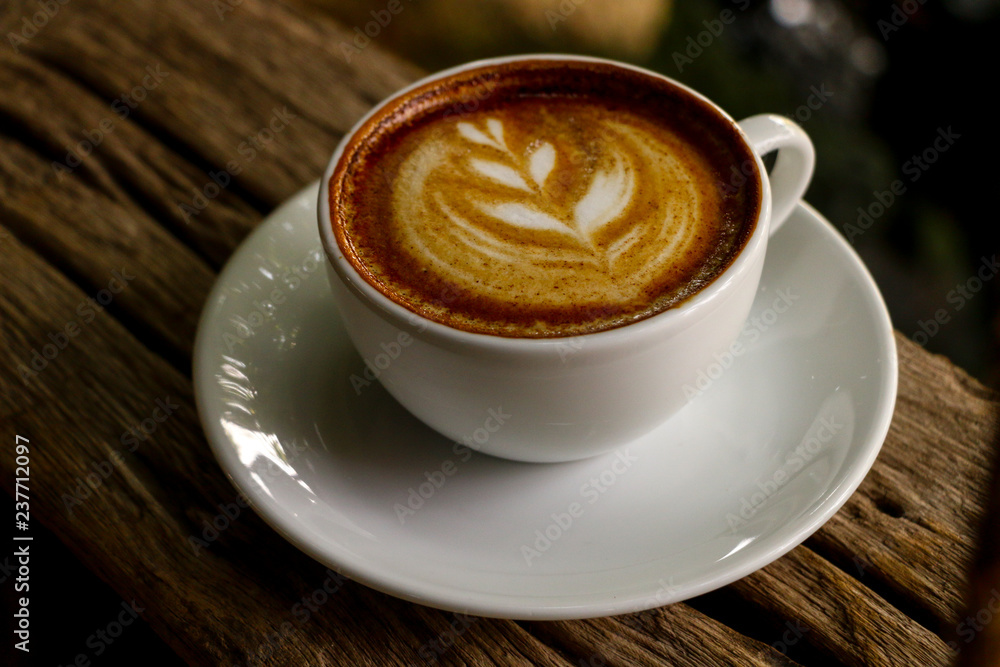 Hot cofffee cup on wooden with painting leaf Hot cofffee cup on wooden with painting leaf