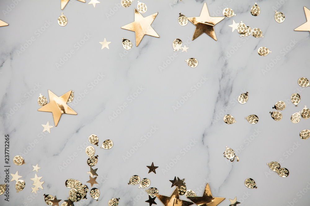 Gold star sparkle party confetti on a marble flat lay background - obrazy, fototapety, plakaty 