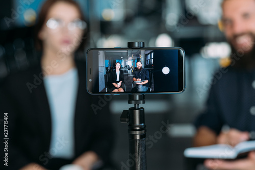 Canvastavla business man and woman shooting video using smartphone on tripod
