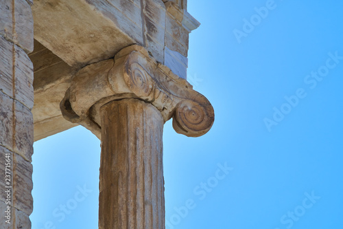 Detail of ancient volutes on a classical Ionic capital against a blue cloudless sky at the temple of Athena Nike.