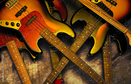 Red and yellow bass guitars stacked in disarray