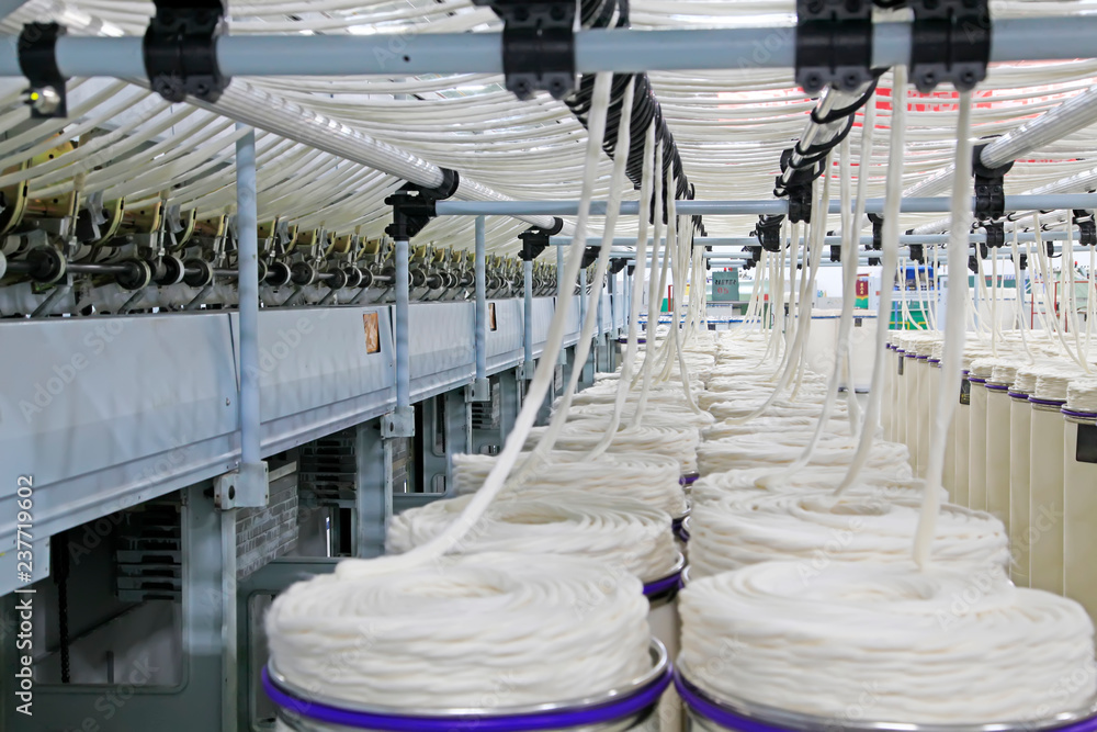 Spinning machinery and cotton yarn barrels in the production workshop,  closeup of photo Stock Photo