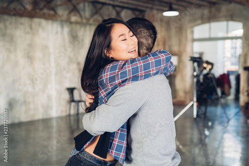 Couple hugging in open plan studio photo