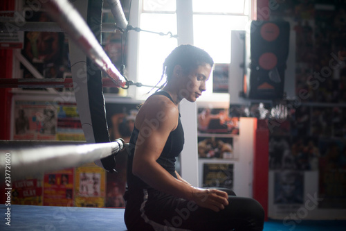 Female boxer by boxing ring photo