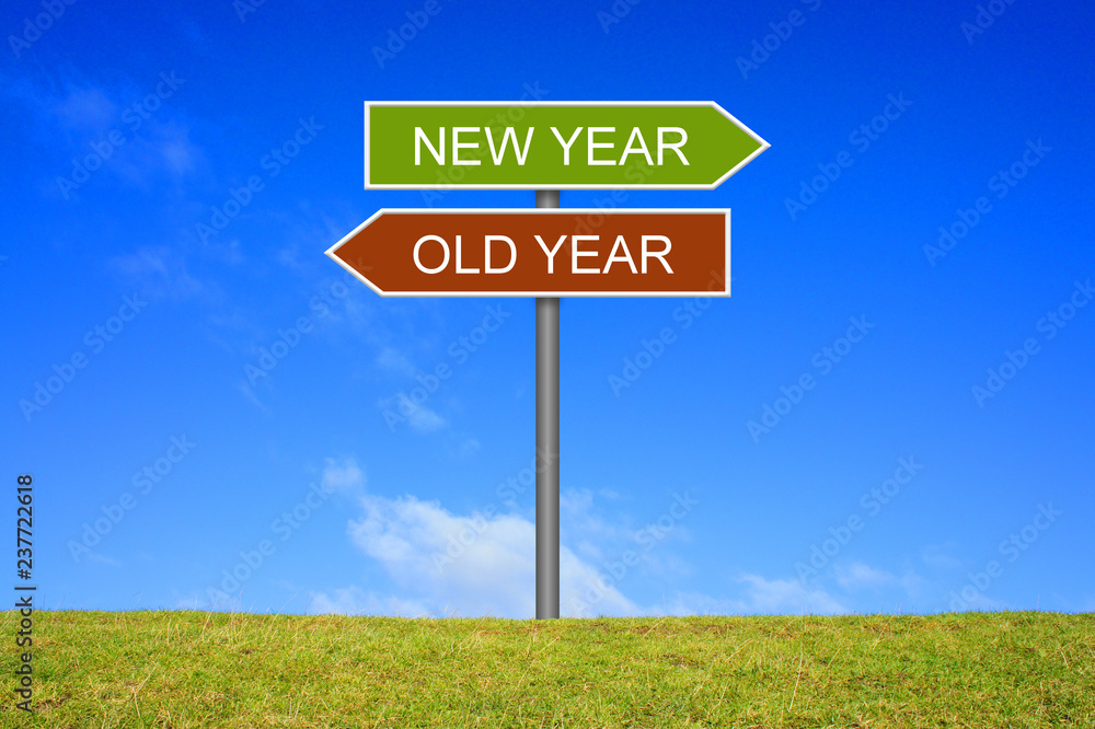 Schild Wegweiser auf Wiese zeigt altes Jahr und neues Jahr