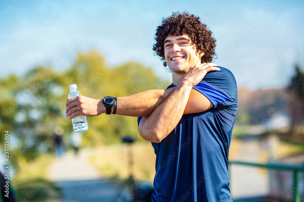 fitness man stretching outdoors - fitness, sport, training and lifestyle concept . fitness man stretching outdoors - fitness, sport, training and lifestyle concept .
