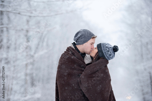 Romantic young couple kissing in snowy forest, Ontario, Canada photo