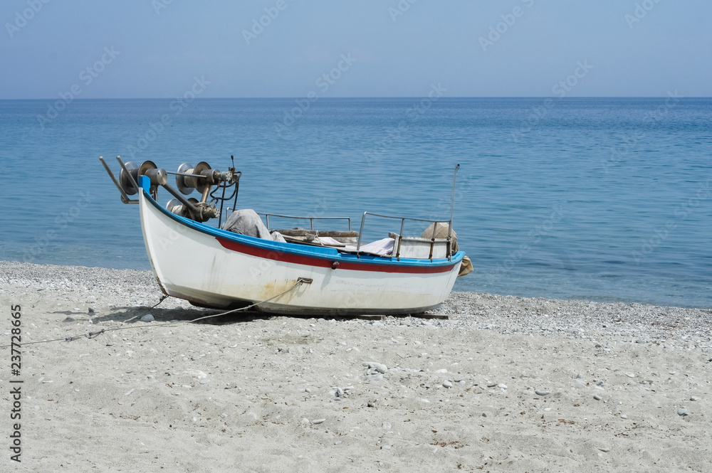 Abandoned fishing boat on beach near sea.