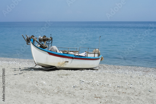 Abandoned fishing boat on beach near sea.