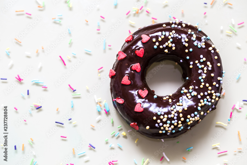 homemade doughnuts with colored frosting and different sprinkles on white background