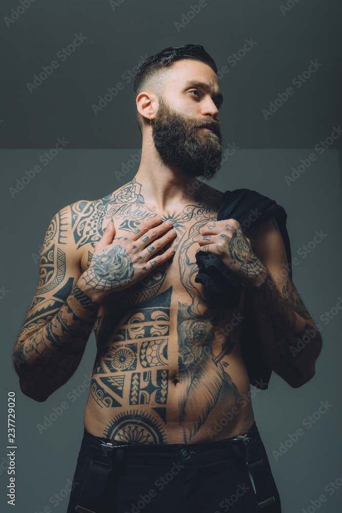 Portrait of young man with beard, bare chest covered in tattoos Stock Photo | Adobe Stock Portrait of young man with beard, bare chest covered in tattoos Stock Photo | Adobe Stock