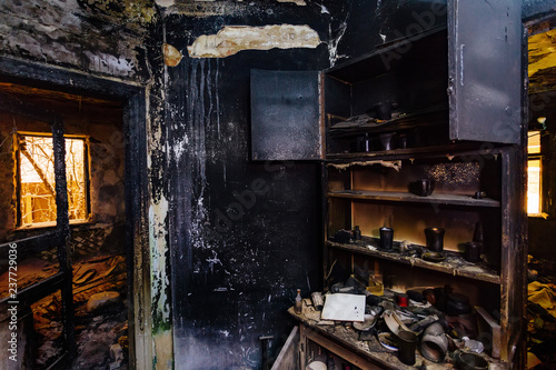 Burnt house interior. Burned furniture, kitchen cabinet, charred walls and ceiling in black soot