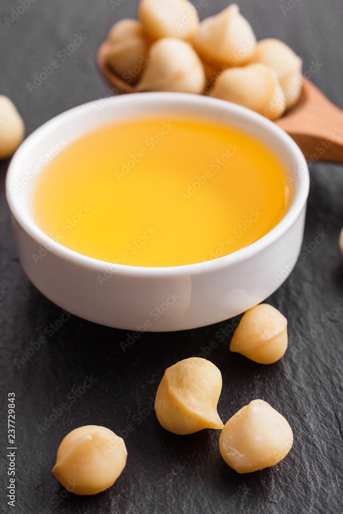 delicious macadamia nuts on a dark stone background delicious macadamia nuts on a dark stone background