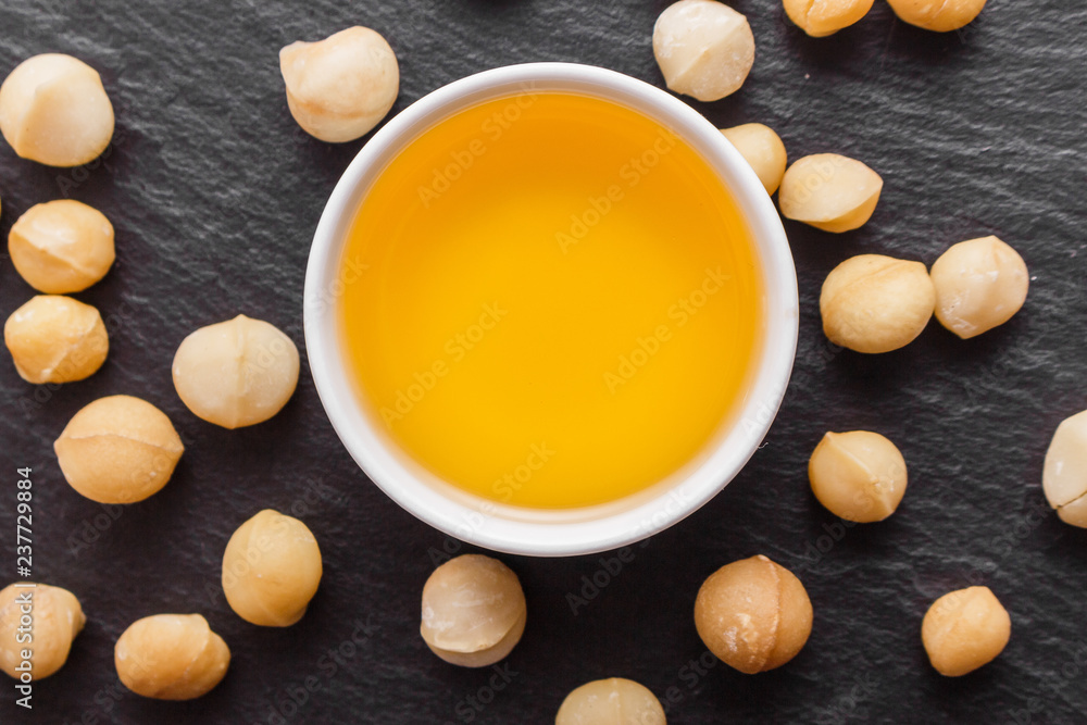 delicious macadamia nuts on a dark stone background delicious macadamia nuts on a dark stone background