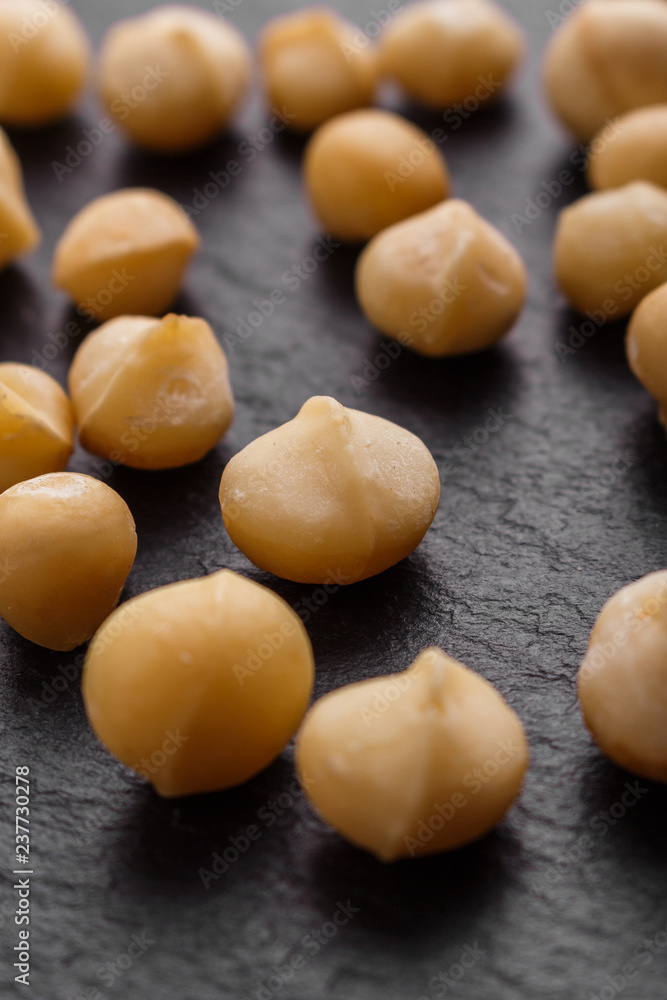 delicious macadamia nuts on a dark stone background delicious macadamia nuts on a dark stone background