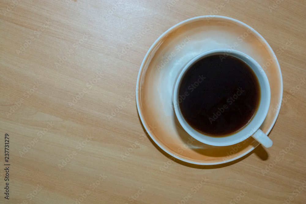 Obraz premium a Cup of coffee on a light wooden table.