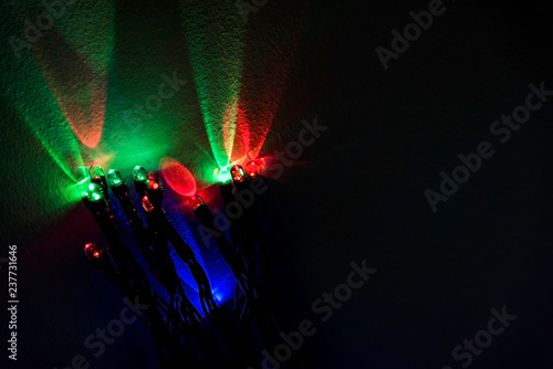 Red, green, blue christmas lights reflections on a wall, isolated