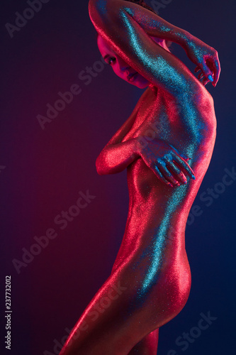 sexy girl gold-plated glittering posing in neon light
