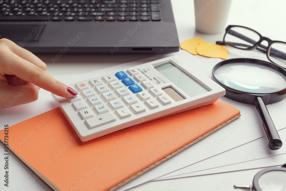 Business woman working with financial data hand using calculator Business woman working with financial data hand using calculator