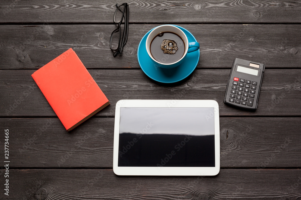 blank tablet device over a wooden workspace table with coffee top view blank tablet device over a wooden workspace table with coffee top view